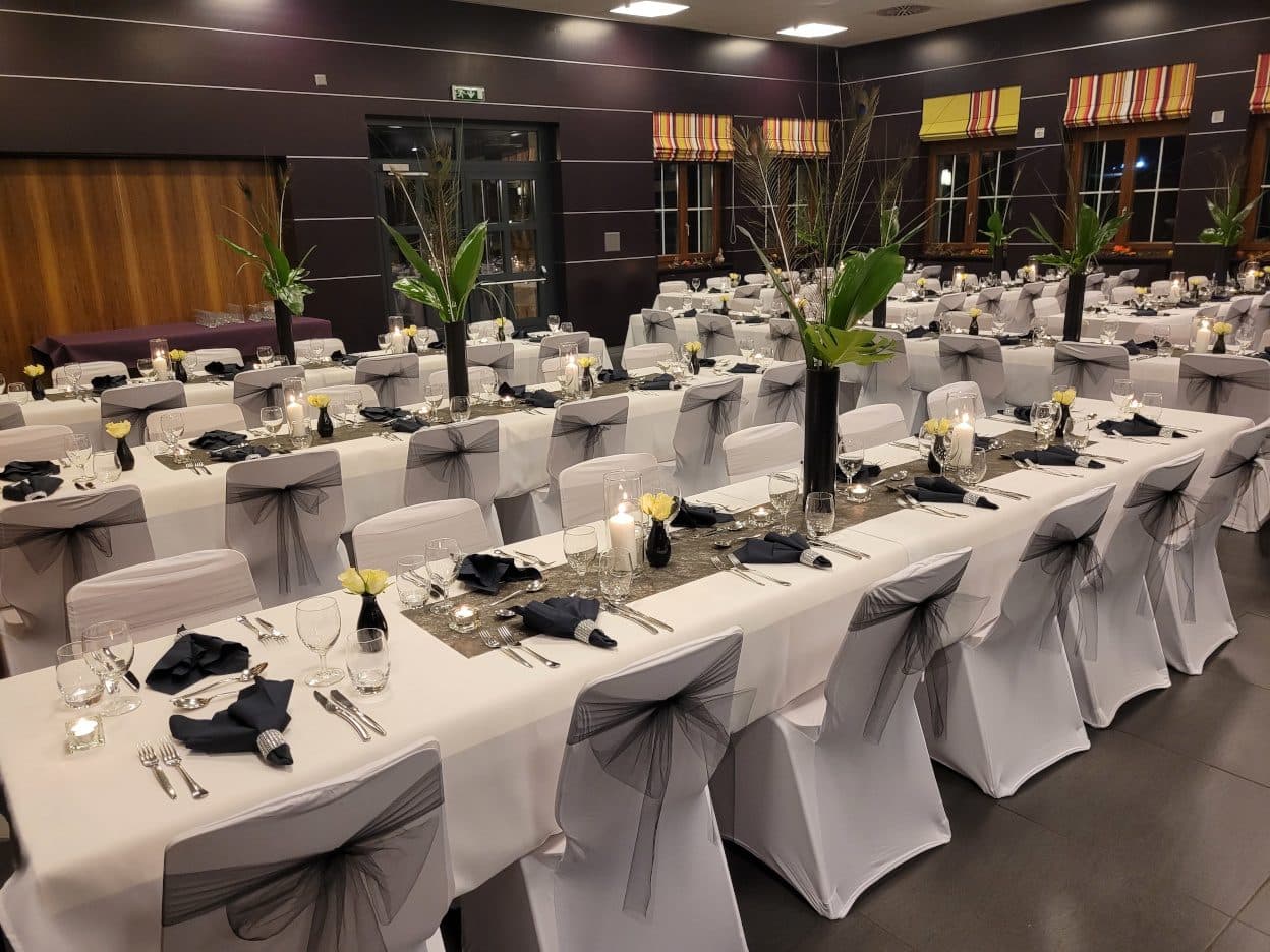 Longues tables habillées de noir et blanc pour un repas de société