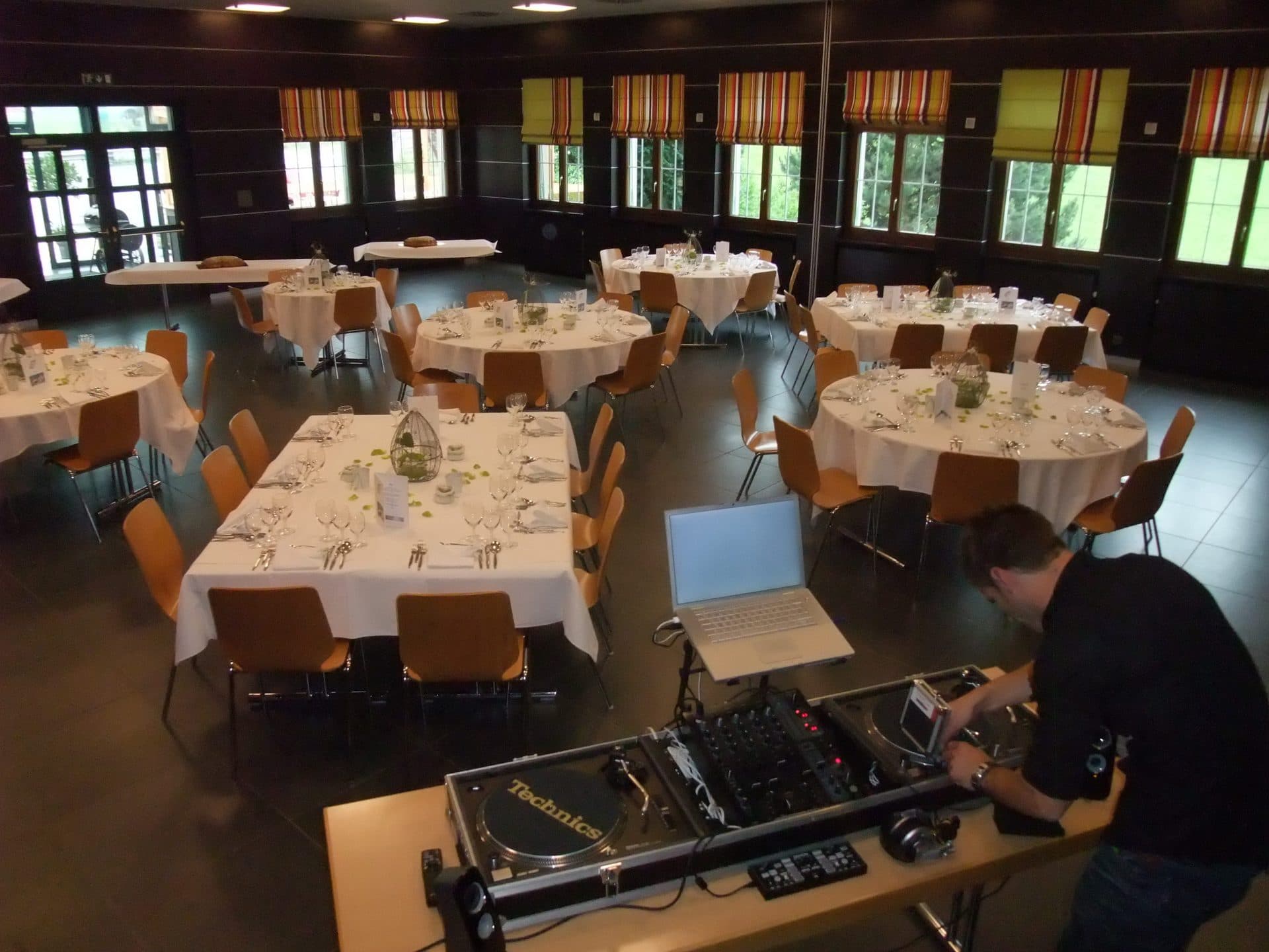 Tables rondes dressées pour un banquet dans la grande salle